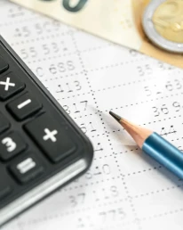 calculadora dinero y lapiz closeup sobre un fondo borroso mini